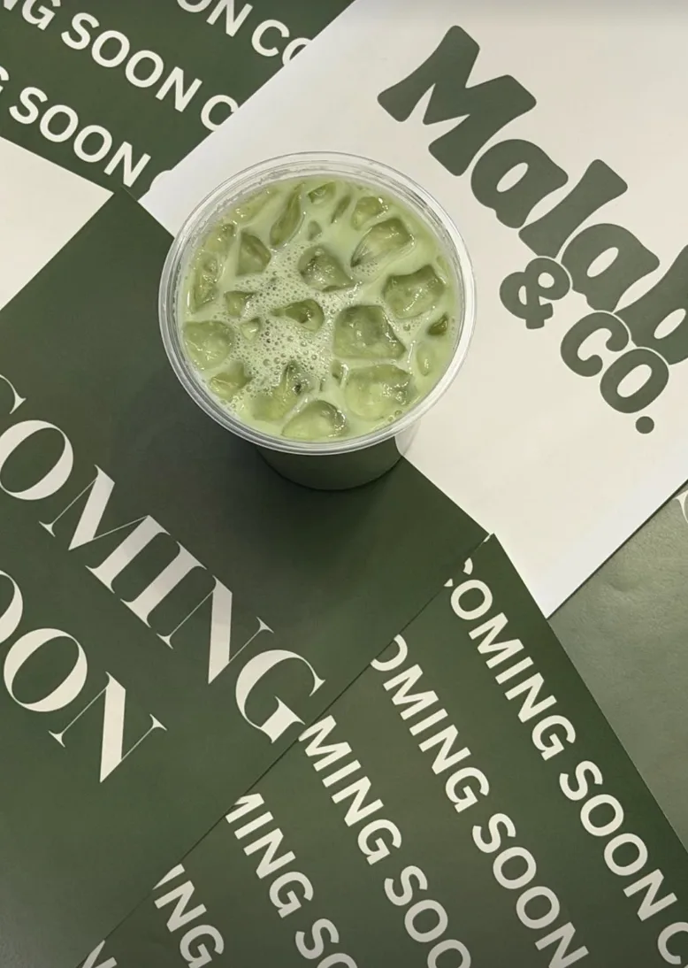 An iced Malab matcha from above on green and cream Malab paper
